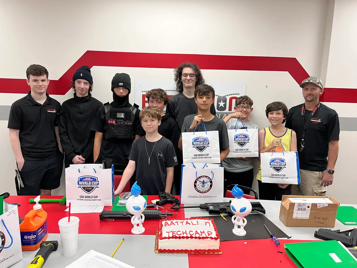 Tech Camp kids with their instructor and a Battalion Tech Camp cake