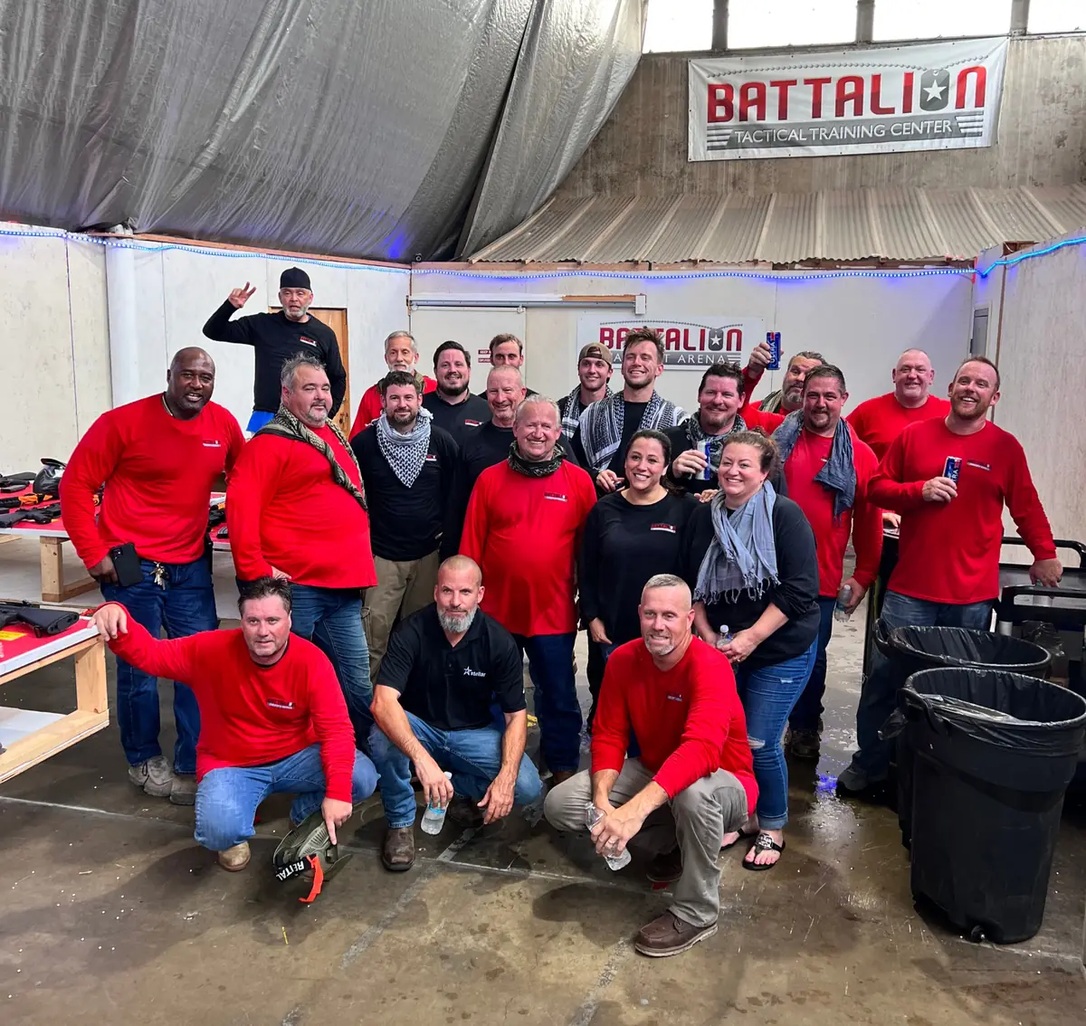 About twenty people in red Battalion shirts under the Battalion Tactical Training Center banner